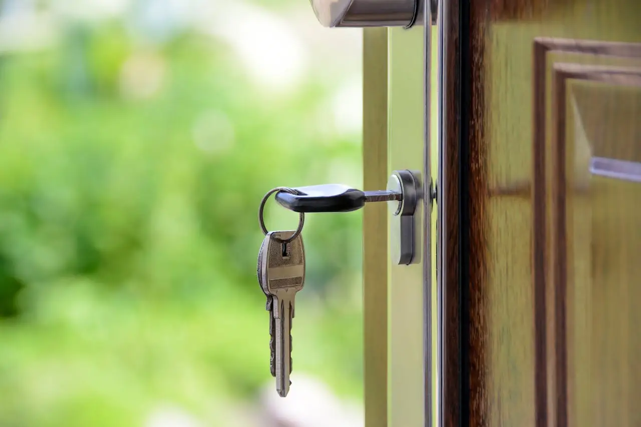 about-01 Key inserted in door lock against a blurred green background, symbolizing security and real estate.