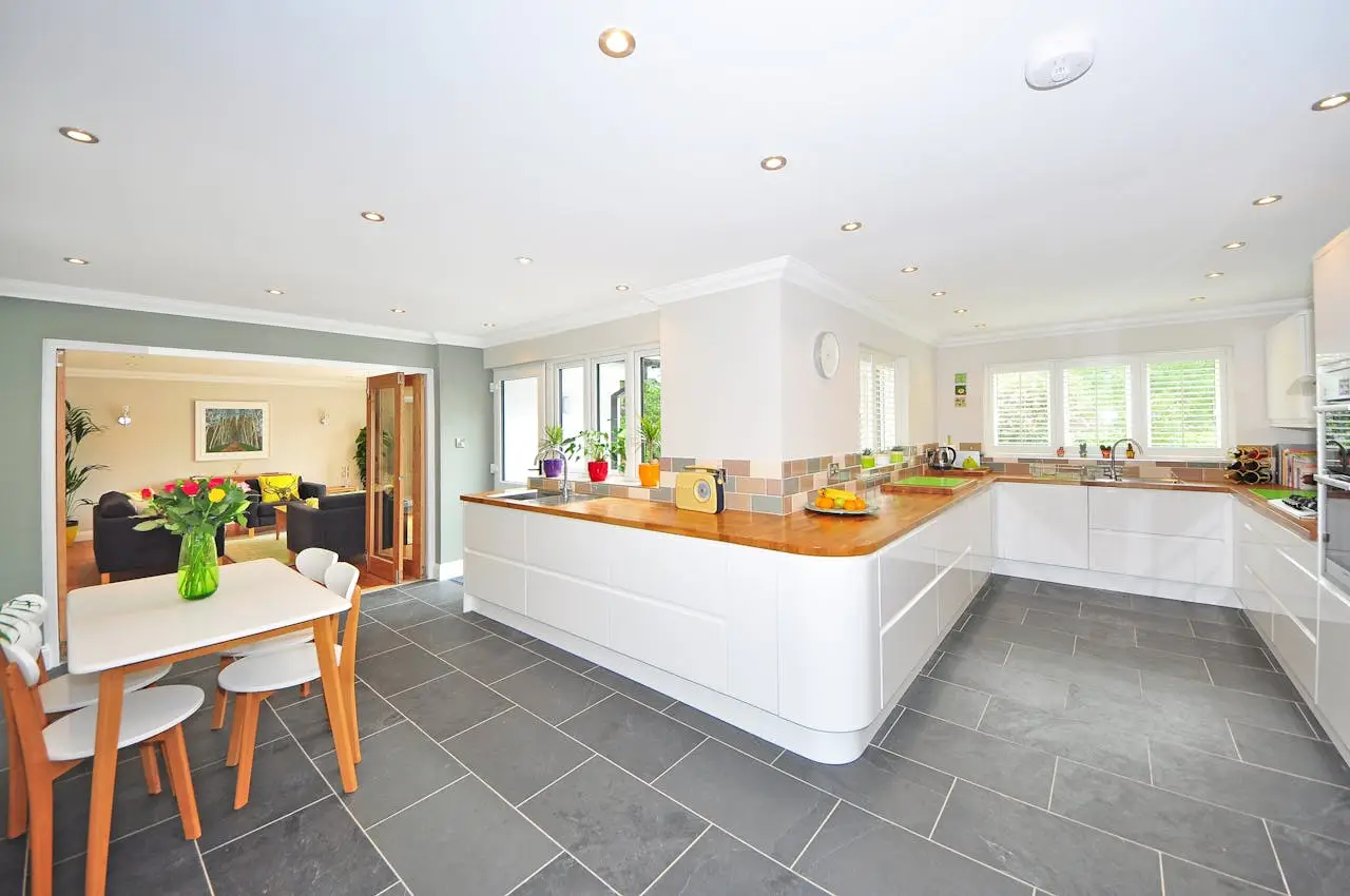 gallery-6 A spacious modern kitchen with elegant interiors featuring a dining table and luxurious design.