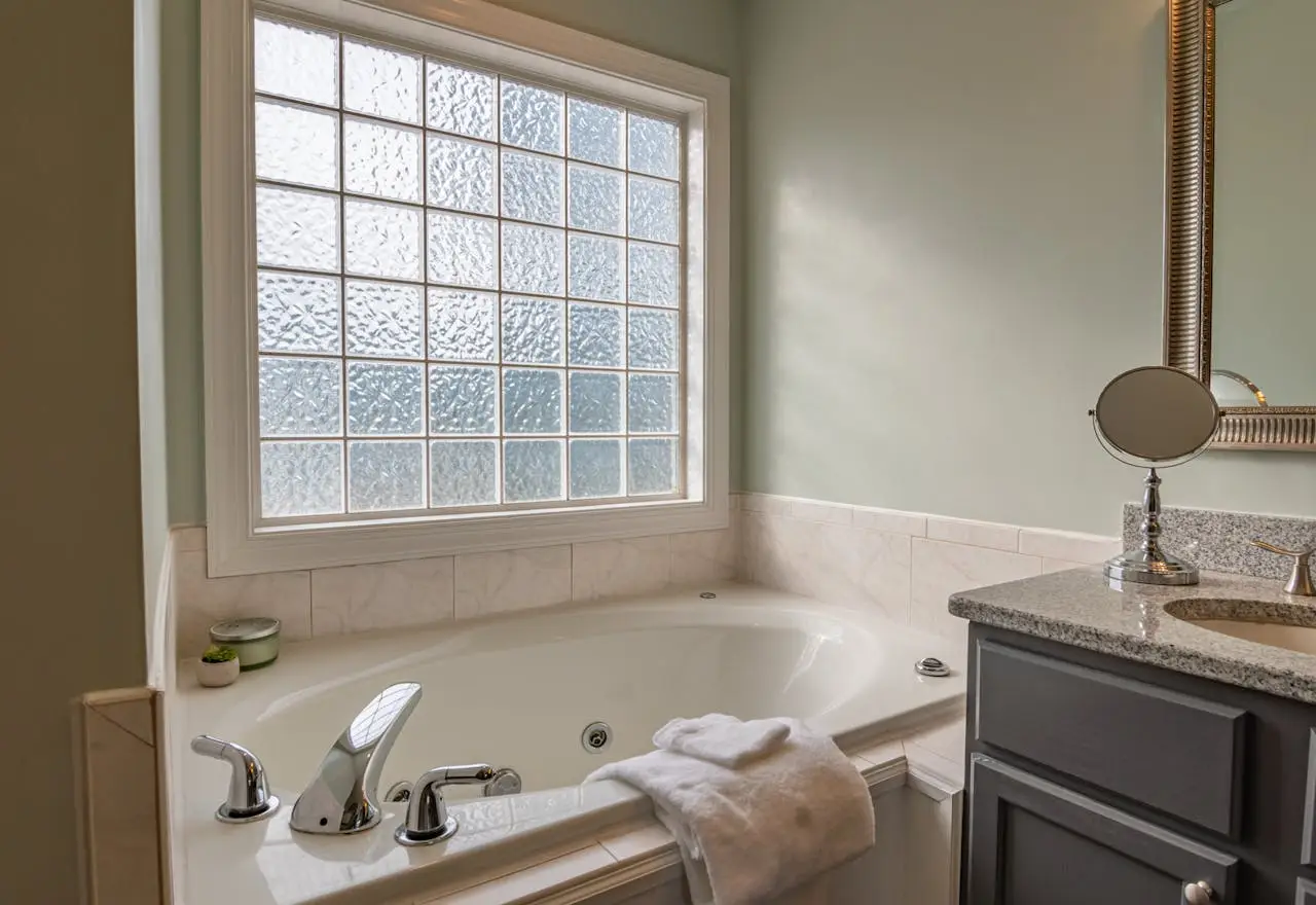 hero-img-02 Stylish modern bathroom featuring a luxury bathtub, sleek sink, and large window. Perfect for relaxation.