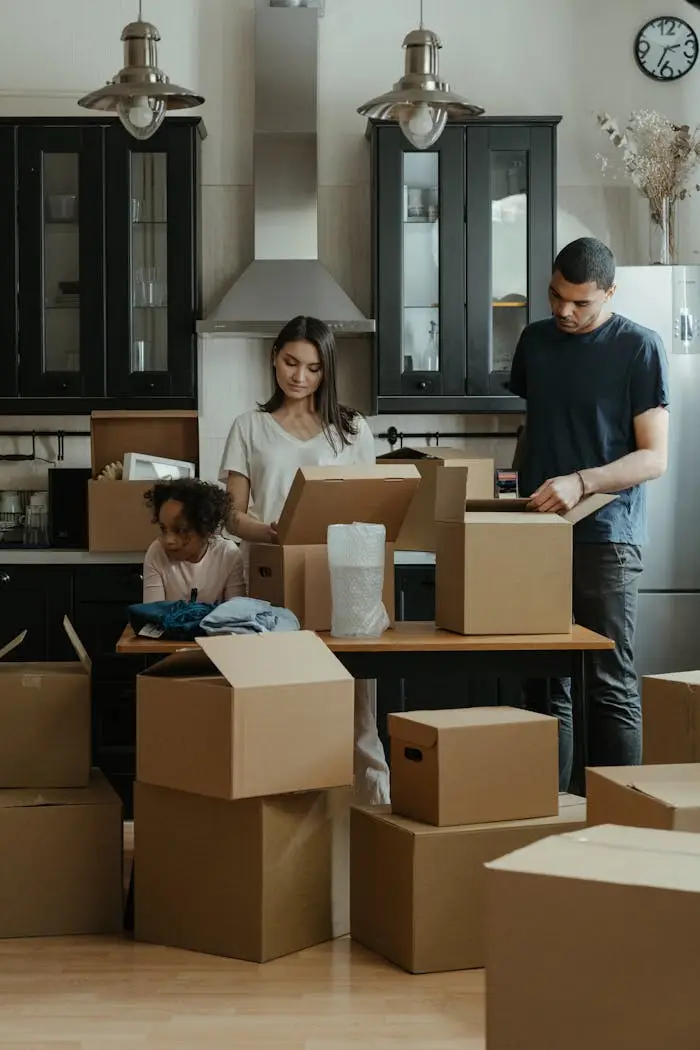 gallery-5 Family unpacking boxes together in a modern kitchen after moving into a new home.